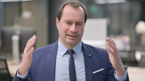 Frustrated Man Gesturing in Office Setting
