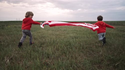Children Running with American Flag in a Field