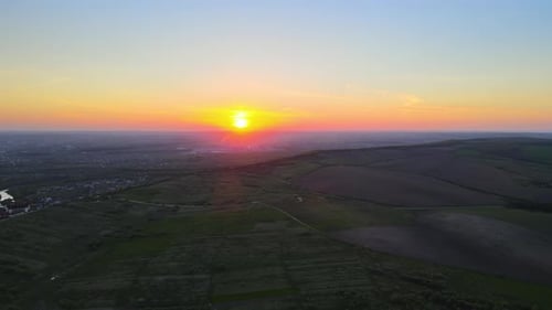 Aerial Landscape View of Green Cultivated Agricultural Fields with Growing Crops and Distant Village