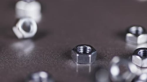 Langsam fallen mehrere Nüsse auf den metallisierten Arbeitstisch