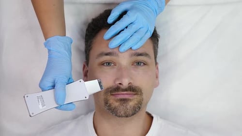 Man Receiving Professional Facial Treatment in Clinic