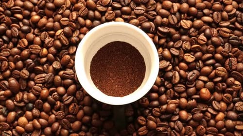 Café moulu sur fond de feuilles de café grillées