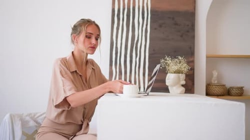 Young Woman Student Gets Online Education Via Laptop at Home