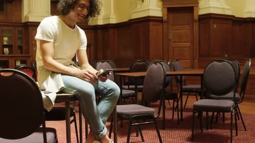Man using mobile phone in the library 4k