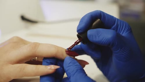 Applying Red Nail Polish at Nail Salon
