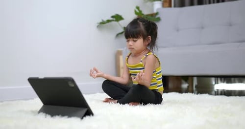 Child Meditating in Front of Tablet at Home