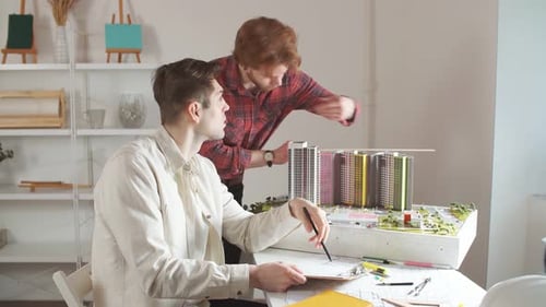 Architects Collaborating on Building Model in Modern Office