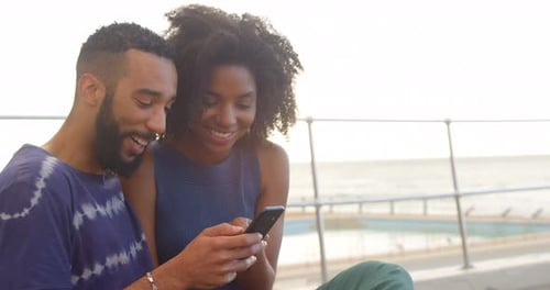 Couple using mobile phone in the beach 4k