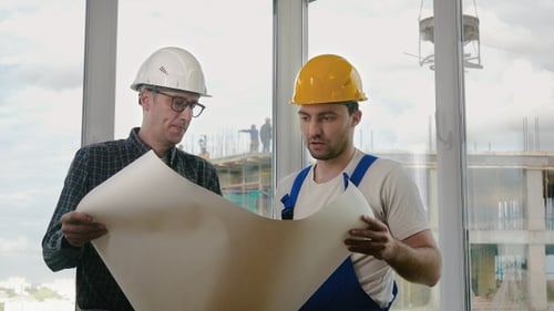 Construction Workers Reviewing Blueprints in Building