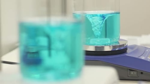 Mixing blue liquid in lab beakers