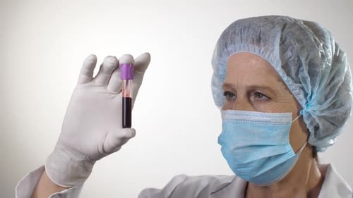 Medical Professional Examines Blood Sample in Vial