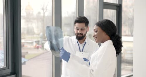Doctor and Coworker Standing and Looking at Xrays in Clinic