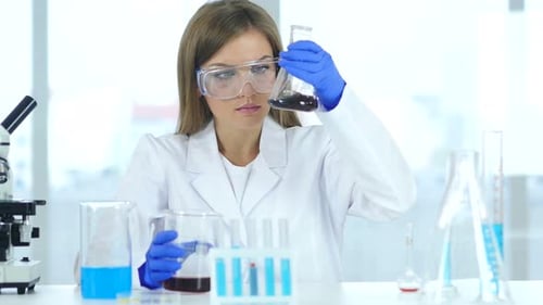 Female Scientist Mixing Chemicals in a Lab