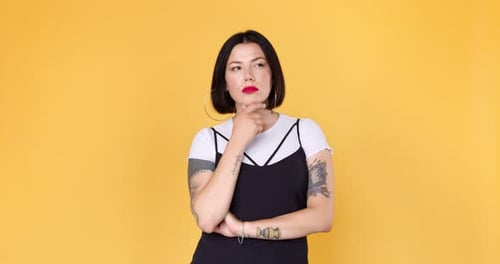 Woman Thinking in Front of Yellow Background