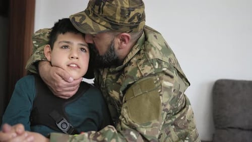 Soldier Hugs Child With Affection Indoors