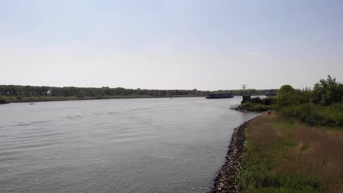 Distant View Of Crude Oil Tanker Sailing On River. wide shot
