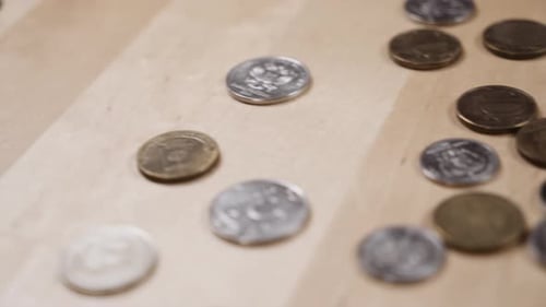 Assortment of Coins Scattered on a Wooden Surface