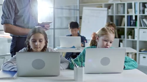 Children Learning with Laptops in Modern Classroom