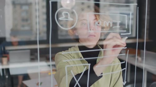 Young Woman Designs Website Interface on Glass Board