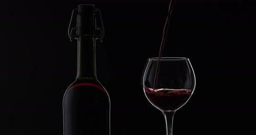 Red Wine Being Poured in Glass on Black