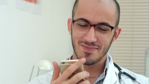Trabajador médico revisando su teléfono y riendo
