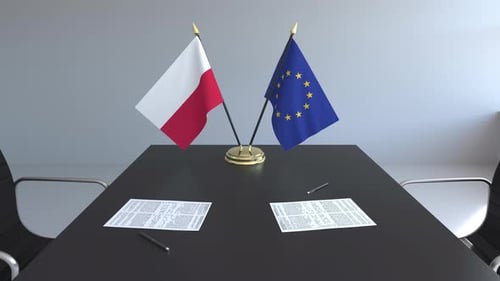 Poland and European Union Flags on Conference Table with Agreements