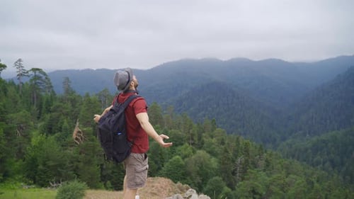 Happy and free tourist on cliff edge.