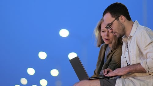 Male and Female College Students Working on Laptop in Library