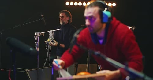 Male Colleagues Creating Various Sounds for Movie in Studio