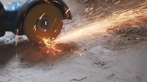 Worker hands cutting metal tube with circular saw with orange sparks