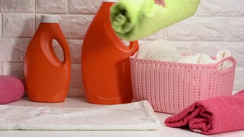 Person Folding Colorful Towels in Laundry Room