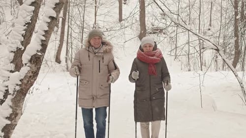 Senior Couple Enjoying Winter Walk in Snowy Forest