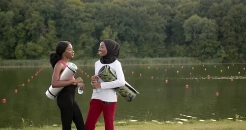Friends Holding Yoga Mats Near Beautiful Lake