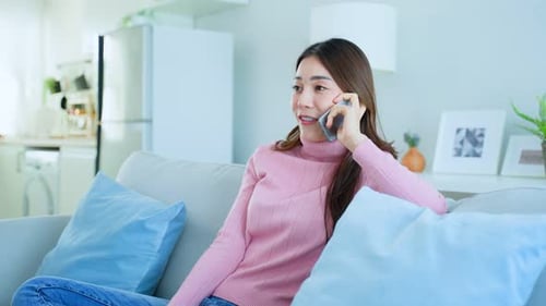 Smiling Woman Talking on Phone on Couch at Home