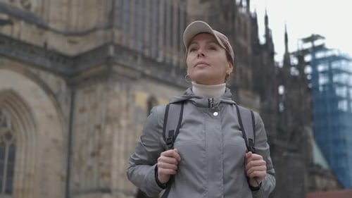 Woman Exploring Historic City with Backpack and Cap