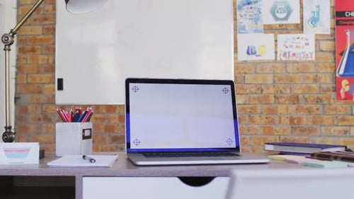 View of laptop and other school supplies on table in the classroom at school