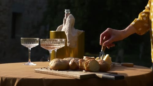 Woman eating cheese and drinking wine in a garden