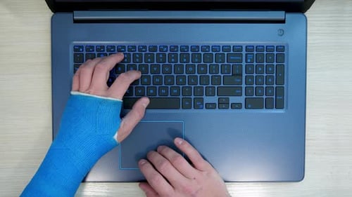 Injured Person Typing on Laptop Computer