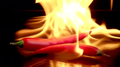 Fiery Flames Surround Two Red Chili Peppers