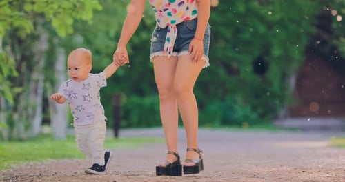 Little Boy Walks with His Mother By the Hand in the Park