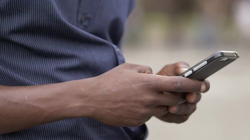 Man Using Smartphone Device in Urban Setting