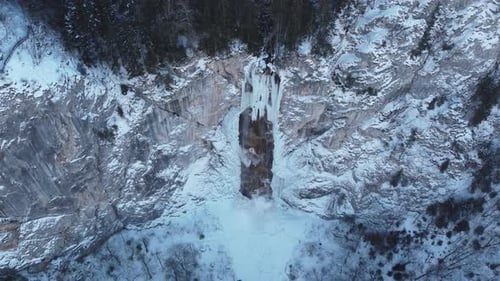 Drohnenblick auf gefrorenen Wasserfall mit etwas fließendem Wasser