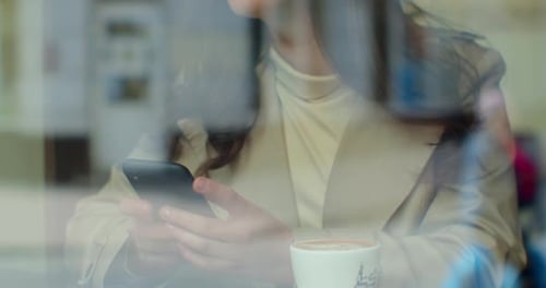 Beautiful Woman Using App on Smartphone in Cafe. Sharing Messages on Social Media Enjoying Mobile