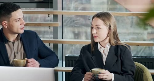 Man and a Woman Discussing Work in the Brightly Lit Modern Office. Male and Female Working with