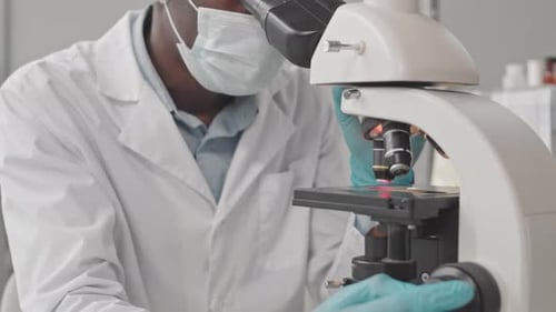 African American Man Using Microscope