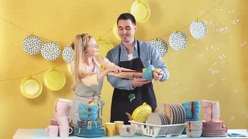 Couple Washing Dishes Together in Yellow Kitchen