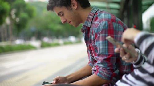 People Using Smartphones at an Urban Bus Stop