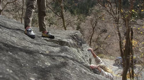 Climbers Helping Each Other on Rocky Hillside