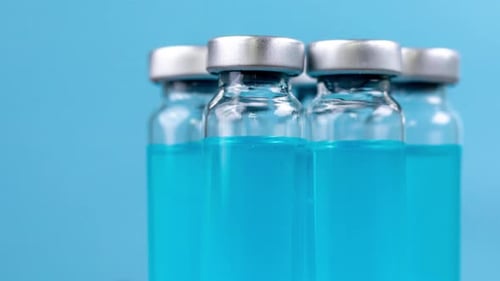 Close Up of Vaccine Vials on Blue Background