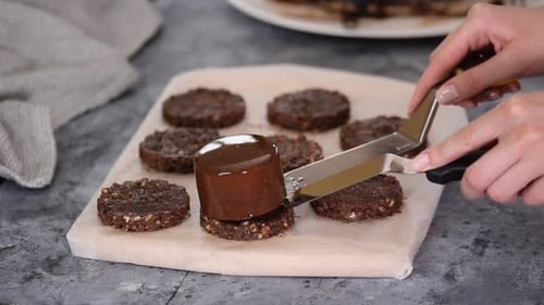 Hands Decorating Chocolate Dessert with Chocolate Mousse